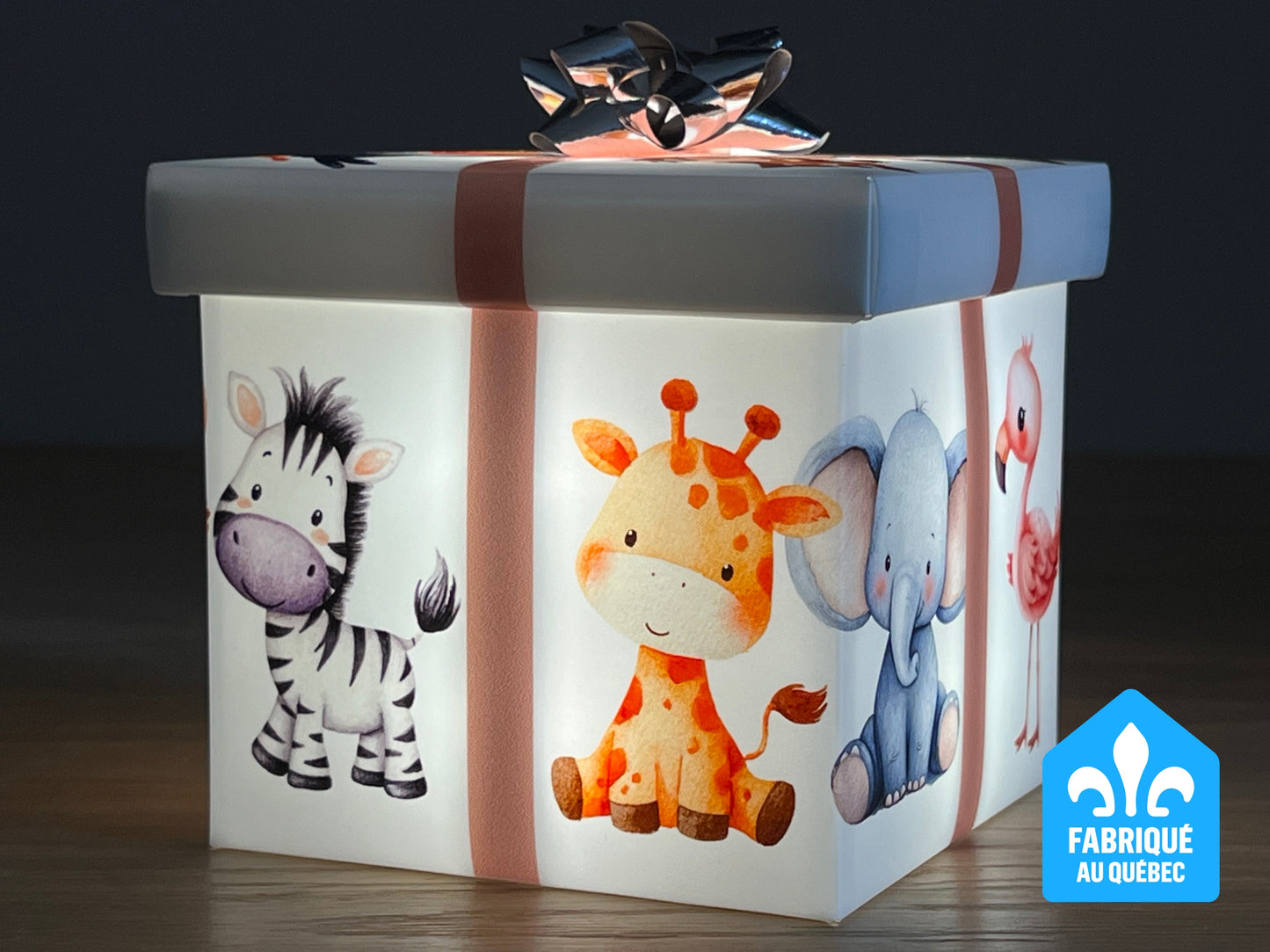 Une boîte cadeau lumineuse carismo pour bébé avec bande rose